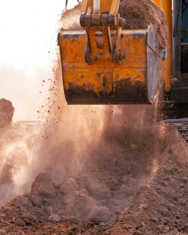 Close-up of excavator at construction site. Backhoe digging soil for earthwork and construction